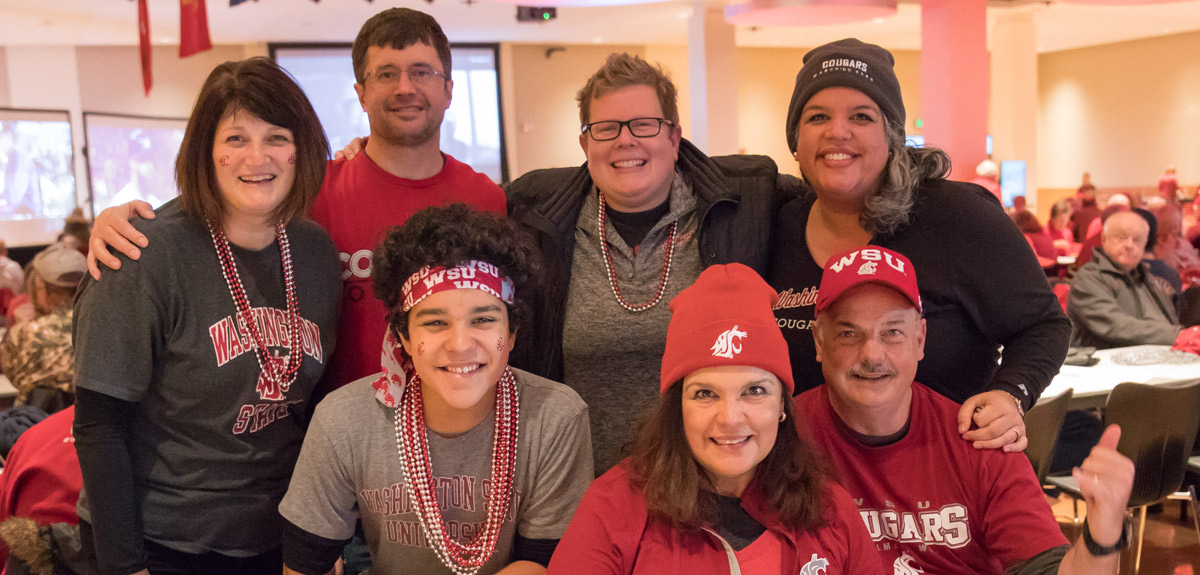 Football fans in Coug gear post for a photo