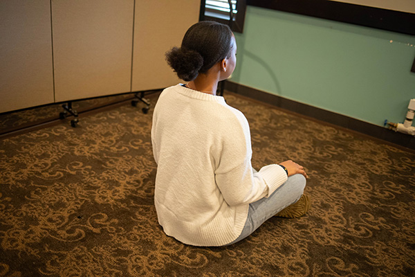 student sits on the floor in meditation