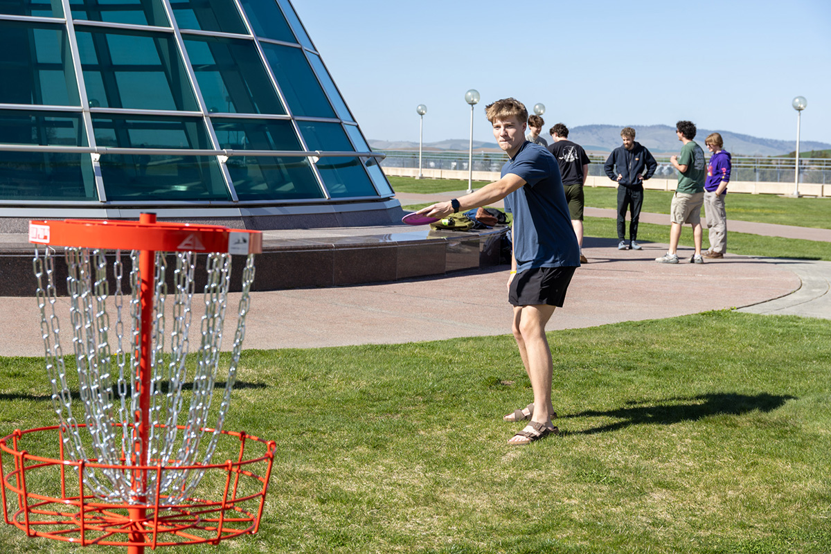 student gets ready to throw frisbee at ultimate disc goal